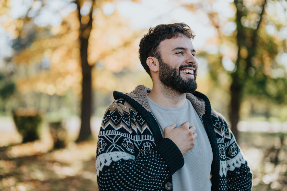 smiling man in a sweater reflecting on mental health struggles