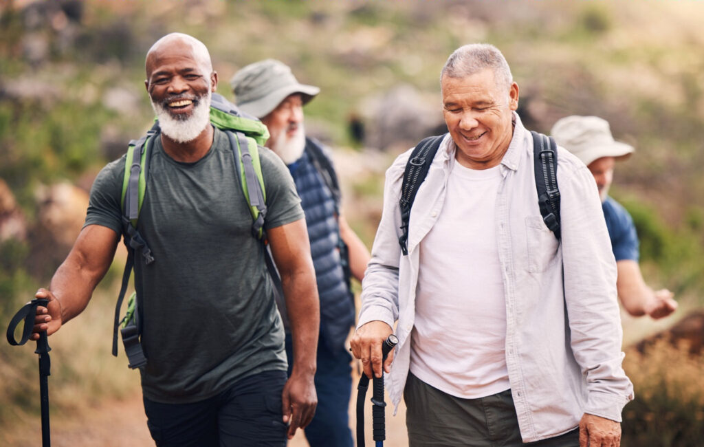 older men hiking a brush-lined trail as part of addiction recovery