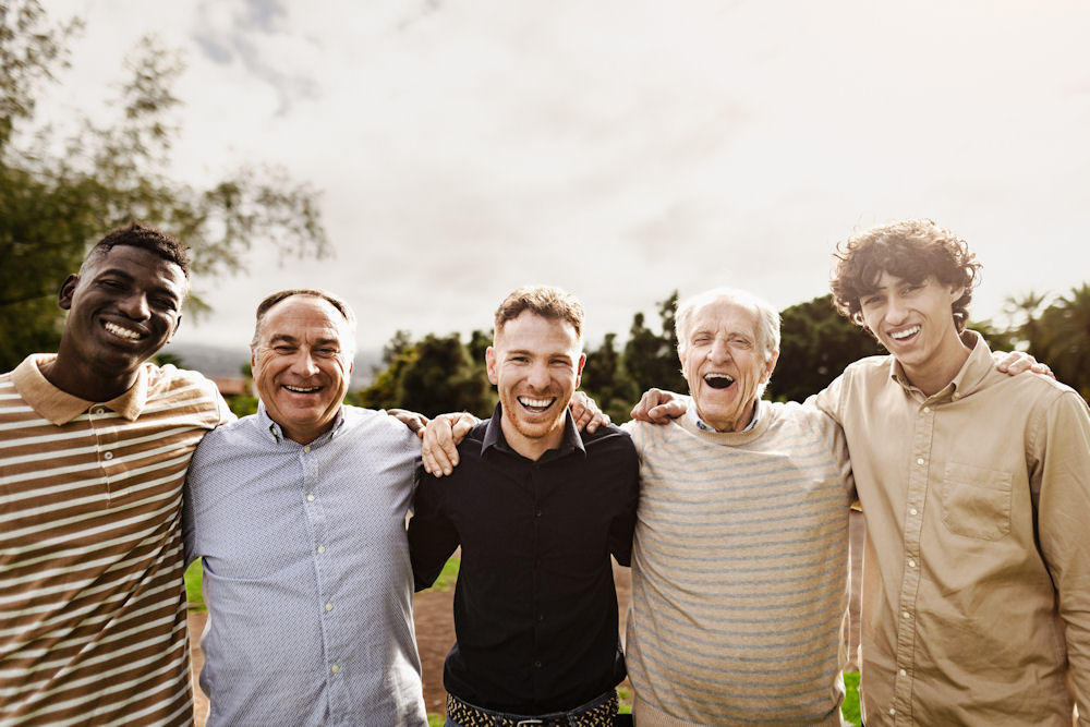 Row of men in addiction treatment giving side hugs.