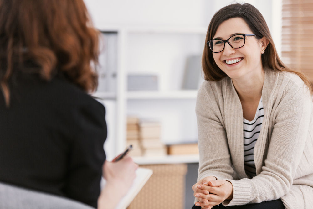 Woman smiles while explaining how marijuana is addictive to woman.